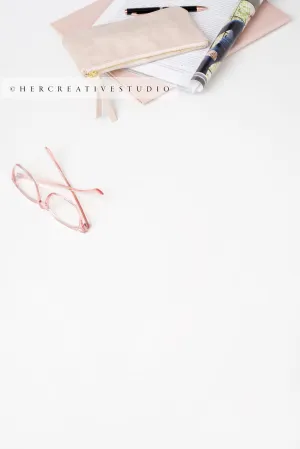 Eye Glasses & Notebook on White Desktop